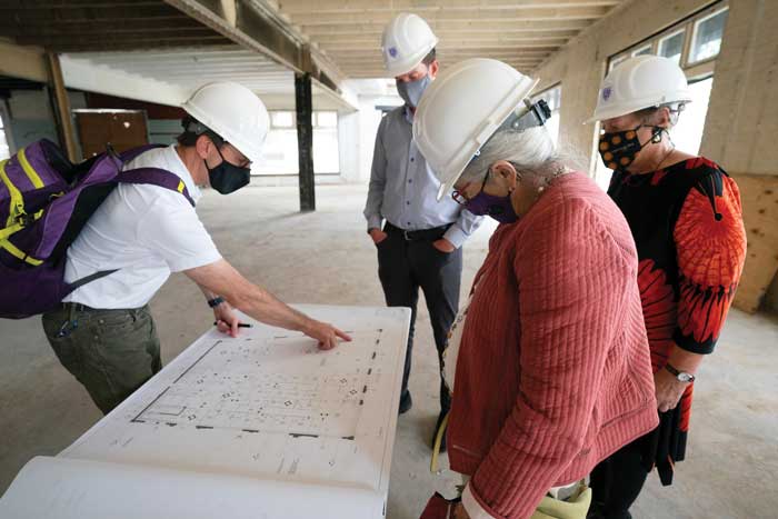 group in hard hats looking at blueprint
