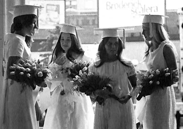 Graduates in white cap and gown